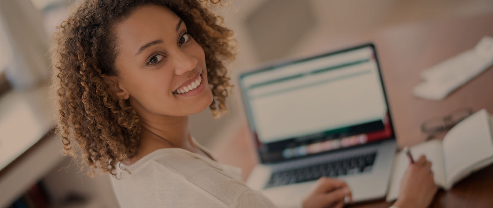 woman smiling while using her laptop